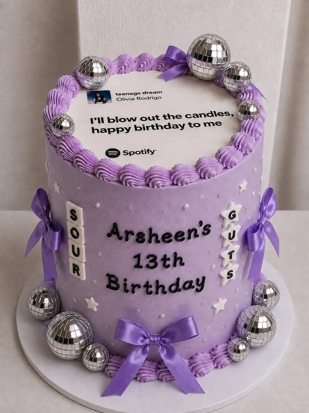 A lilac thirteenth-birthday cake with a Spotify plaque and silver baubles